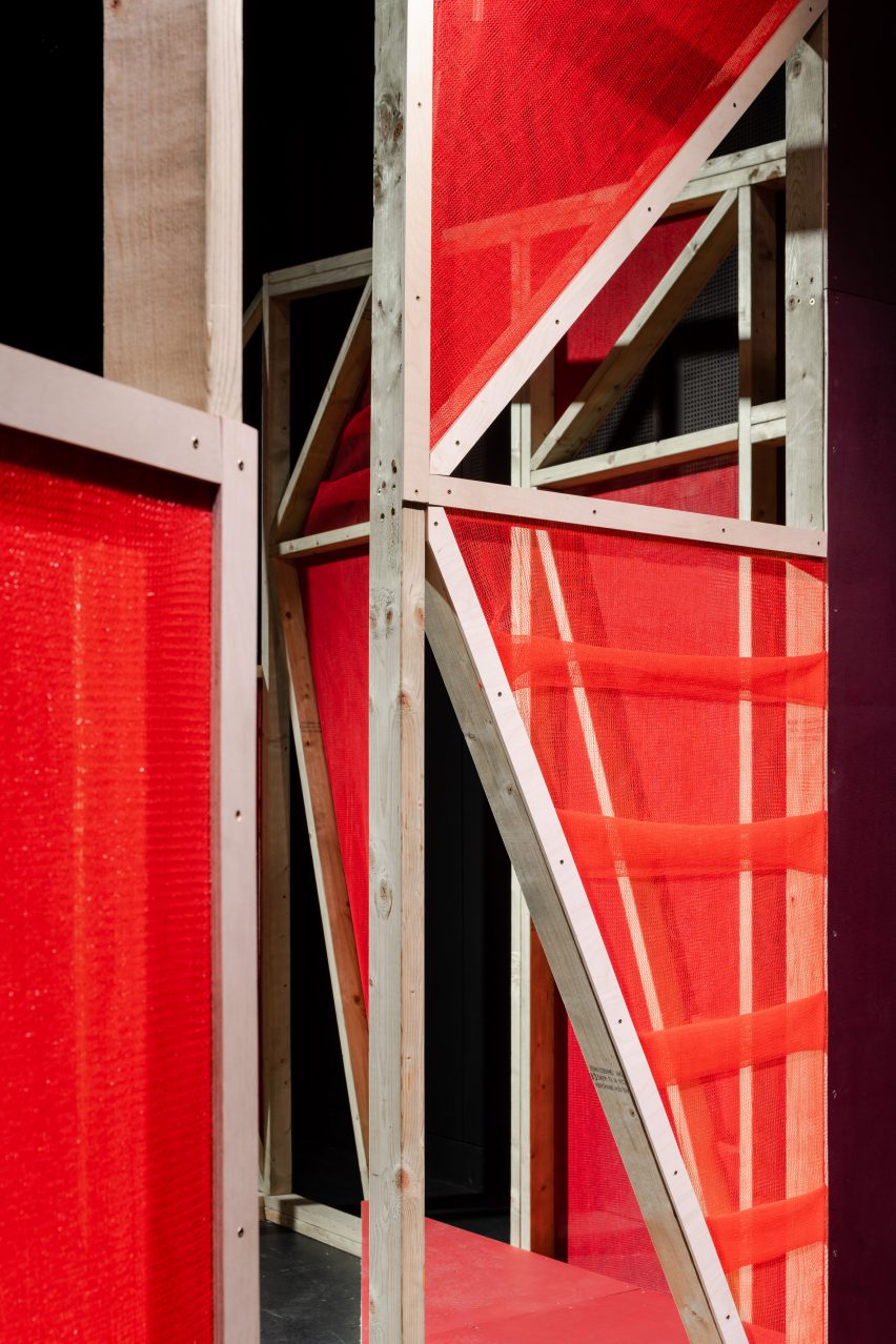 Triangular stages with timber frames and red netting built by school children and Matt+Fiona