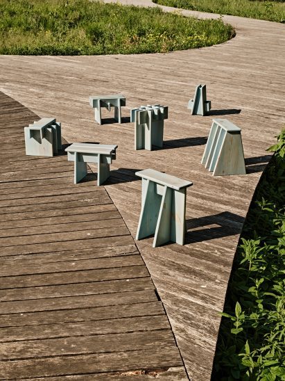 Small blue chairs meant to be used in public displayed on boardwalk