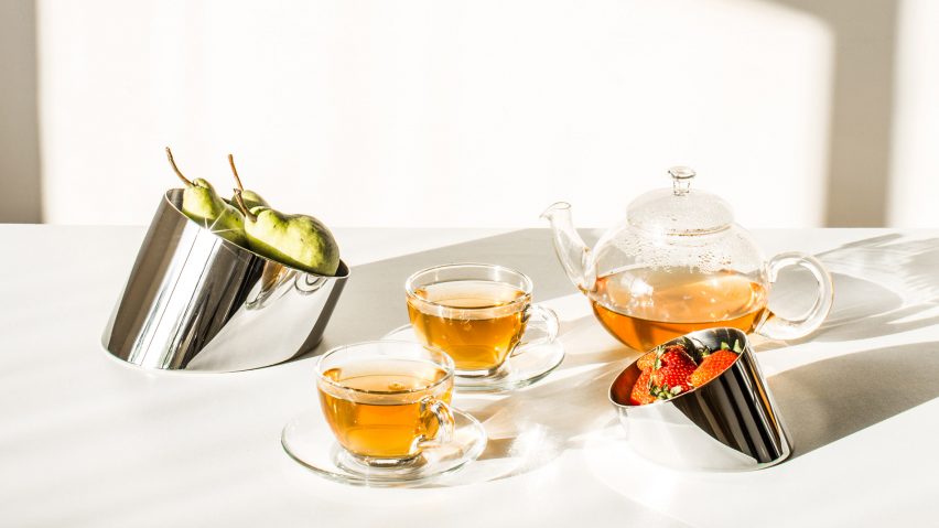 Slanted bowls containing fruit on table