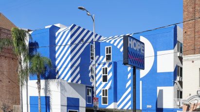 Exterior of the The Alvarado homeless shelter in LA with a graphic blue and white-painted facade