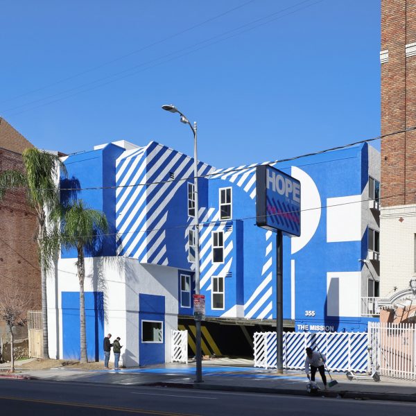 Exterior of the The Alvarado homeless shelter in LA with a graphic blue and white-painted facade