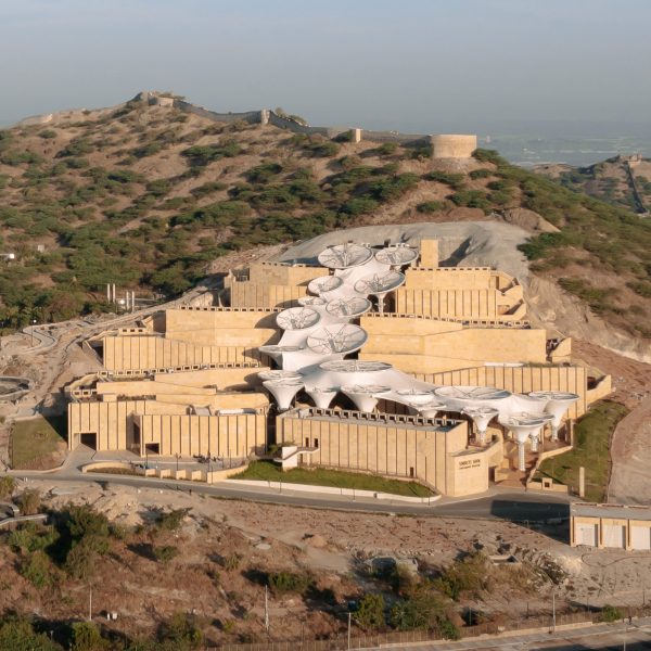 Exterior of the Smritivan Earthquake Memorial Museum by Vastushilpa Constultants with stone walls zigzagging up a sloped site