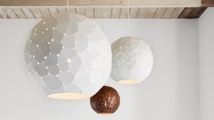 White and bronze-coloured lamp shades hanging in room