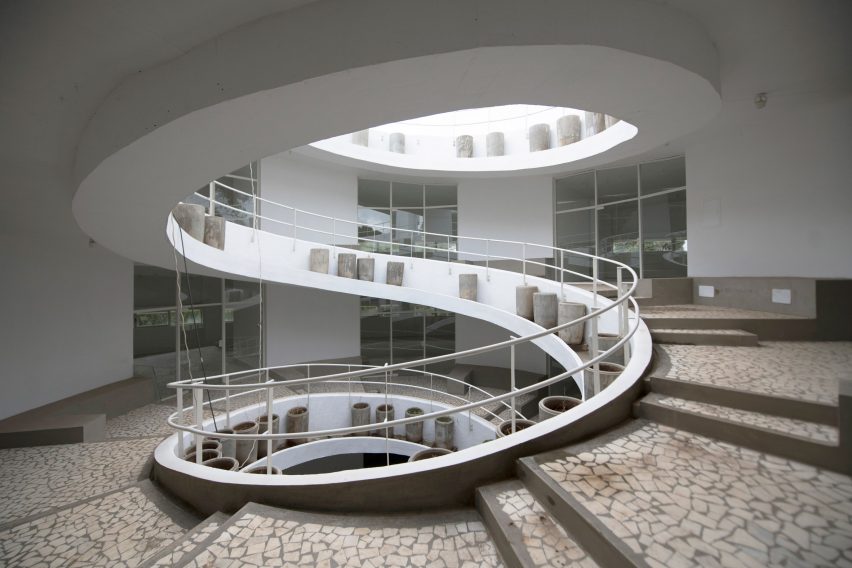 Spiral staircase with wide steps and a circular opening in the roof
