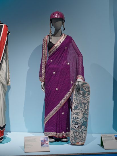 A mannequin in a colourful outfit holding a skateboard