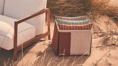 Cushions stacked next to white sofa on beach