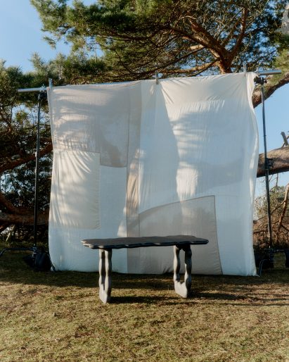 Photo of a black aluminium table by Ferm Living and Anna Maria Øfstedal Eng in front of a sheet