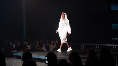 Model on runway wearing white garment