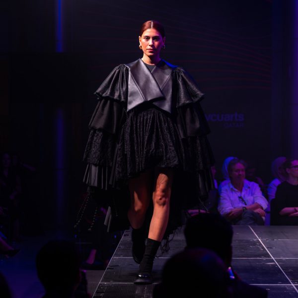 Model on runway wearing black garment