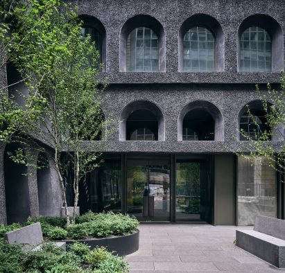 Textured facade and entryway to dark-clad manhattan 
