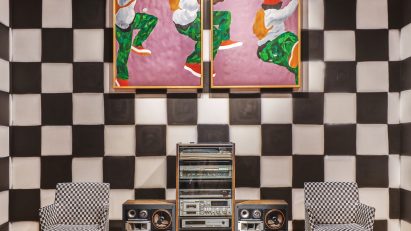 Checkerboard wall behind a stereo and two chairs
