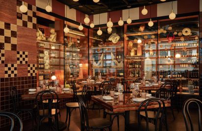Dimly lit dining room with glass walls and bistro tables