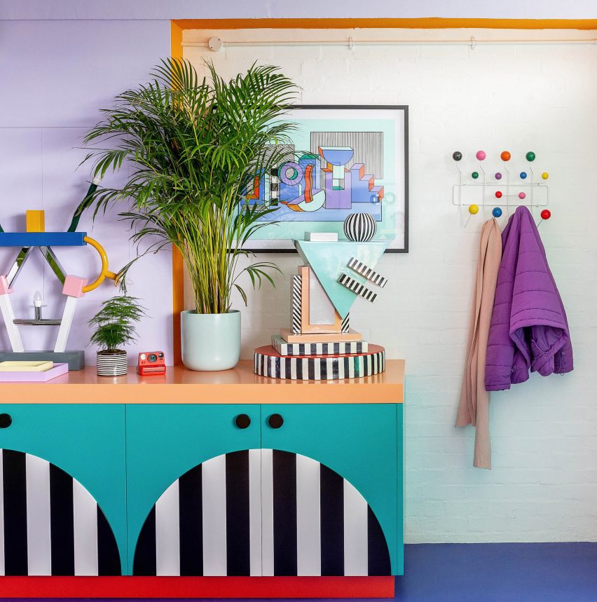 Photo of details in a colourful office space with bold cabinetry, bright blue floors and plants and colourful ornaments on display