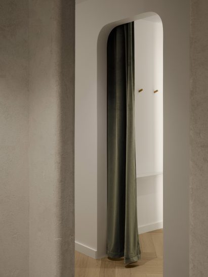 Minimalist fitting room with green velvet curtain