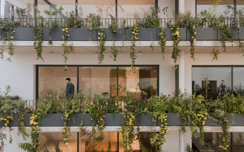 Plant-filled balconies at and apartment building with glass sliding doors