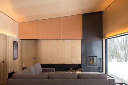 Wooden interior of a sloped living room with steel fireplace