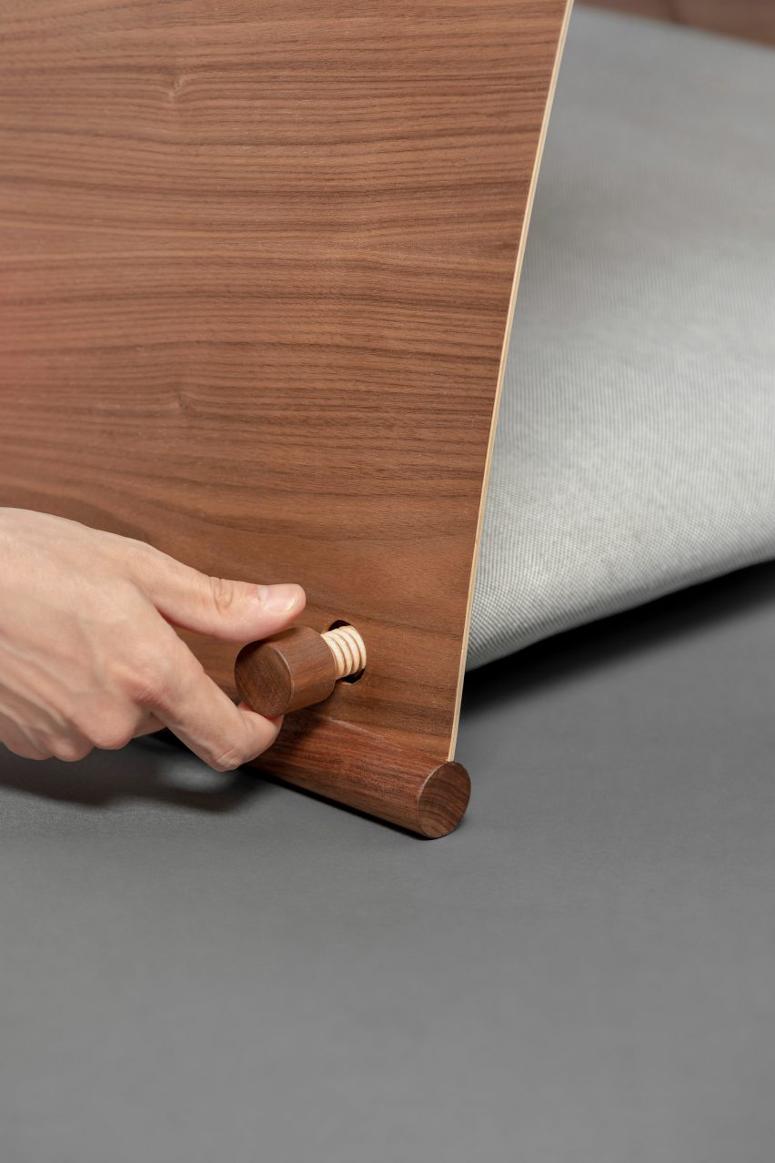 Hand tightening wooden screw on side of dog bed
