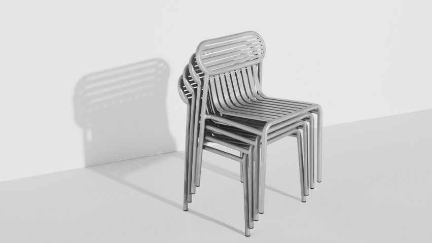 Shiny metallic chairs stacked up in white room