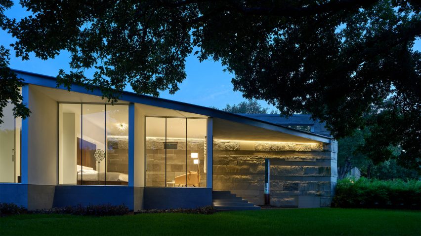 One-storey home with a sloping mono-pitched roof, floor-to-ceiling windows and stone walls