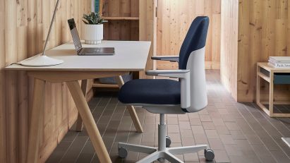Blue upholstered Path office chair by Humanscale in a timber-clad interior at a wooden desk