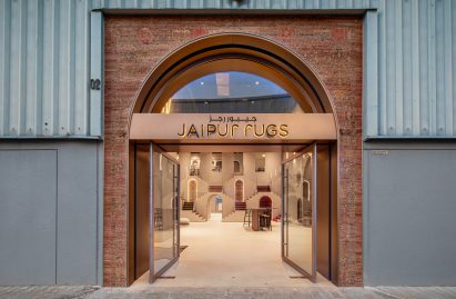 Photo of the outside of Jaipur Rugs Dubai showroom showing a brick entrance with rose gold signage built into a warehouse