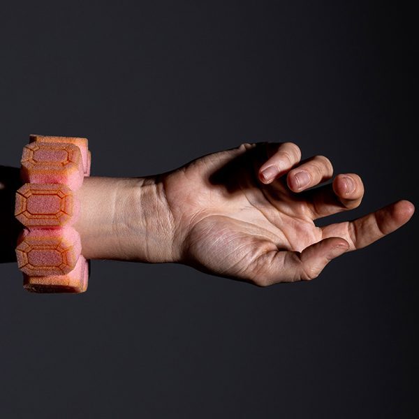 A pink bracelet made of packaging foam shaped into jewel shapes