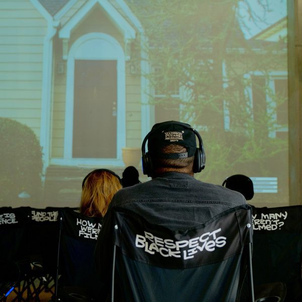 Man watching film on chairs that say "Protect Black Lives"