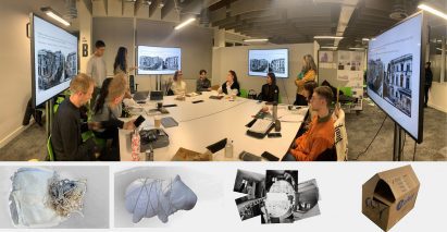 Photograph of students around a table presenting their work on screens