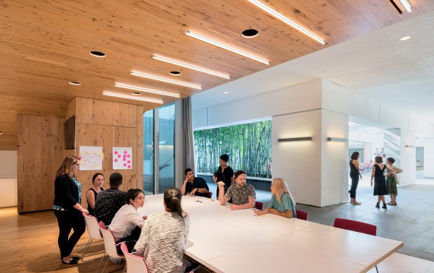 Office meeting space with a large white table and timber ceiling
