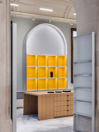 Yellow and wooden cabinets in retail space by Alex Cochrane Architects