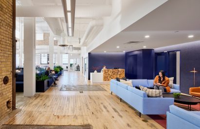 Blue lounge area to the right and open hallway to the left