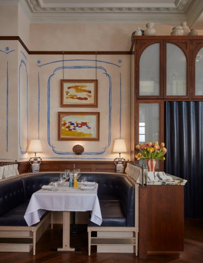 Socca restaurant interior with navy booth seating, dark wood wall panelling and wall murals