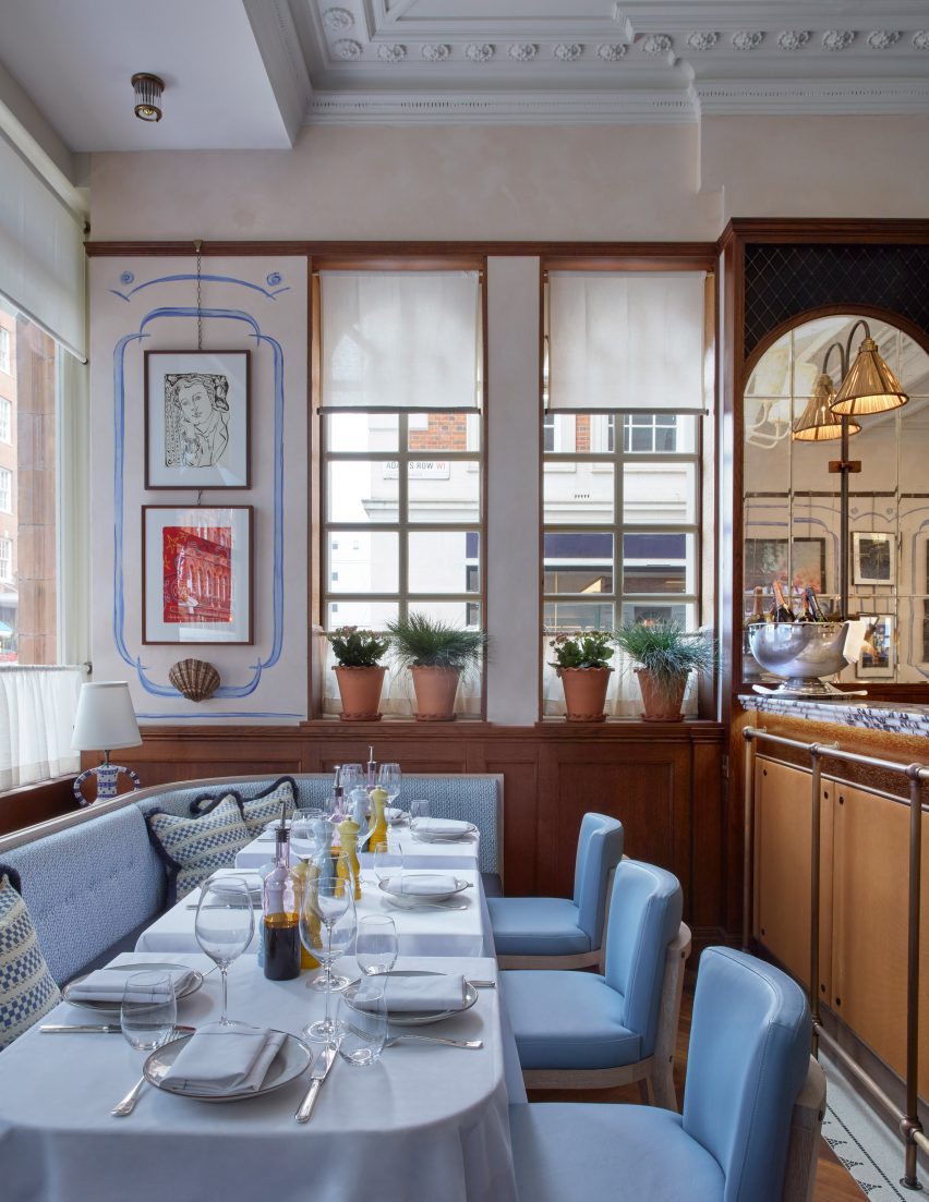 Restaurant interior with blue seating, white stucco walls and wood wall panelling