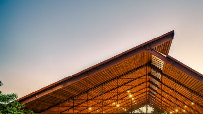 Exterior of the brick Casa de Musica school by Colectivo C733 with a cantilevered timber roof