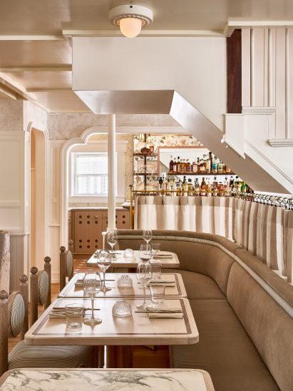 Restaurant tables with pony wall running beneath a staircase
