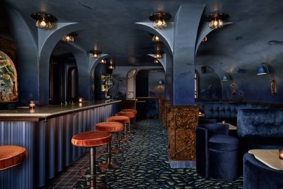 Bar area with rust-coloured stools one the left, and lounge on the right