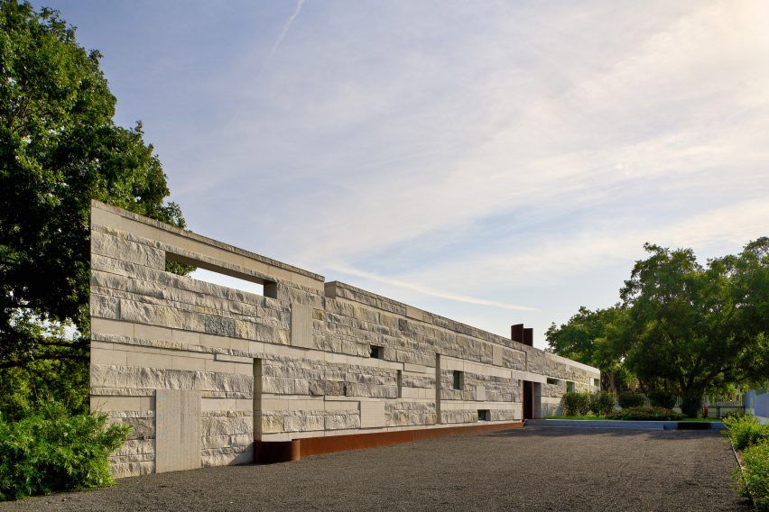 A stone-like wall with rectangular perforations at Casa Escuda by Tobin Smith Architect