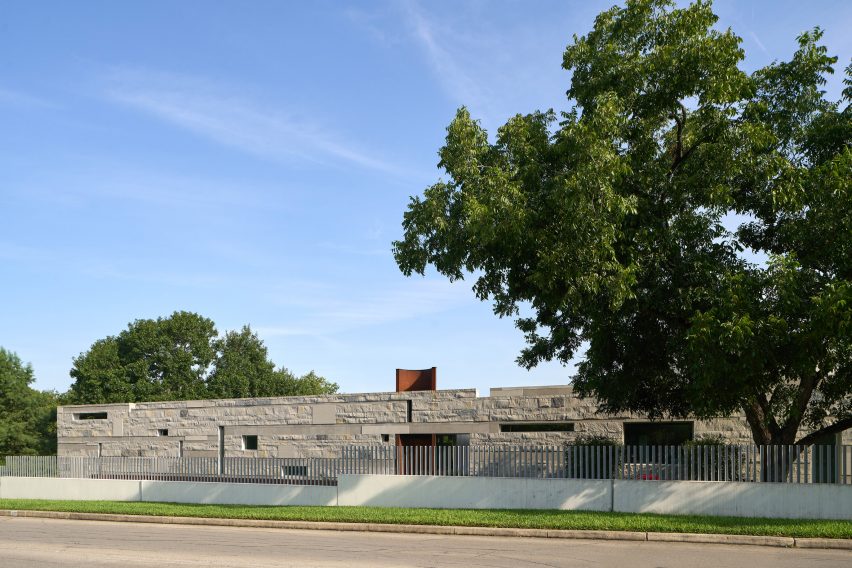 House with stone-like cladding and a weathering steel tower