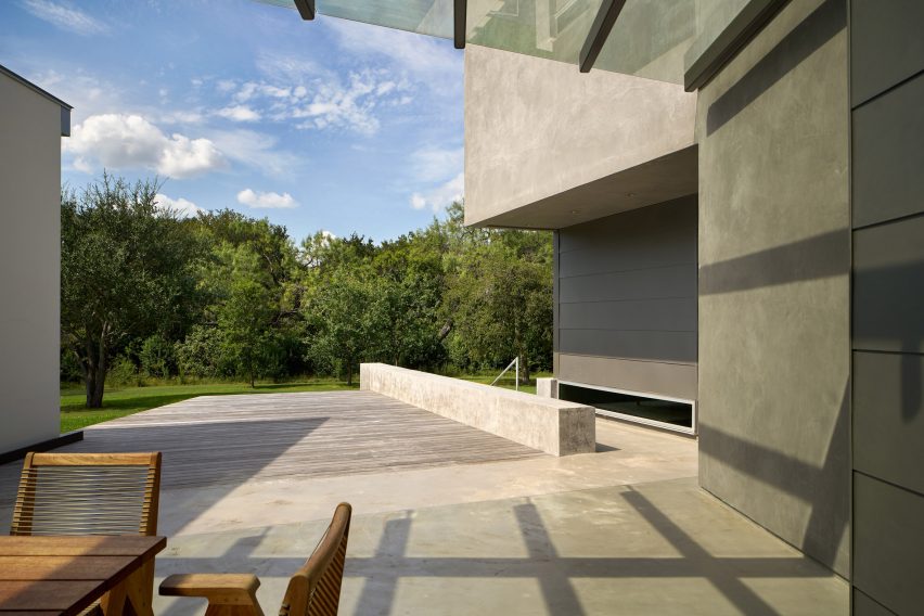 Outdoor stone terrace overlooking a garden with large trees