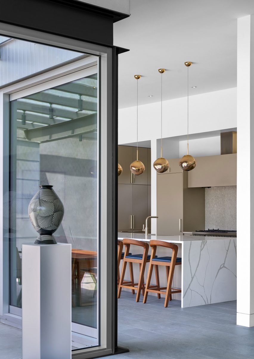 Floor-to-ceiling corner glazing in a room with a marble kitchen island