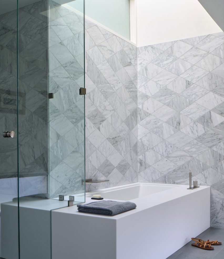 Bathroom with grey geometric wall tiles and a rectangular bath