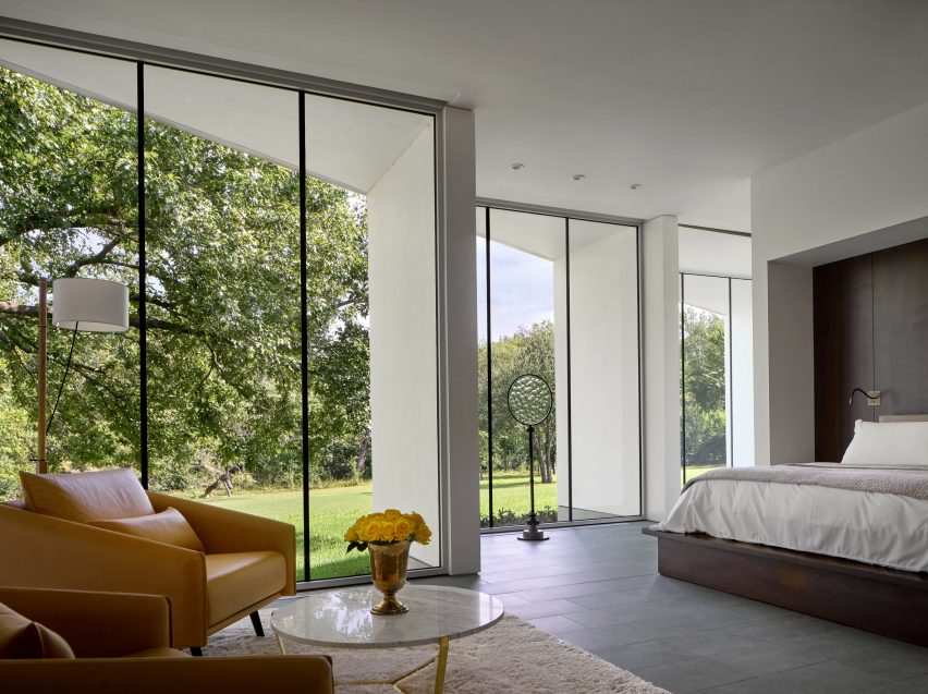 Bedroom with floor-to-ceiling windows, a double bed and a yellow lounge chair