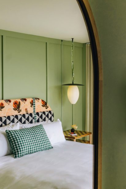 Green-painted guest room reflected in a mirror