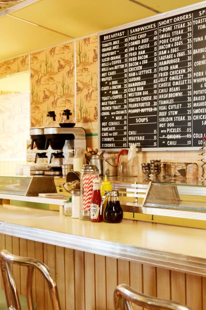 Interior of a 1950s-style diner with a chalk board menu