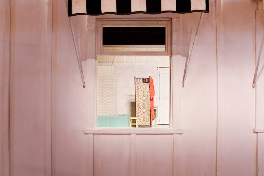A bathroom film set in a white wooden shack