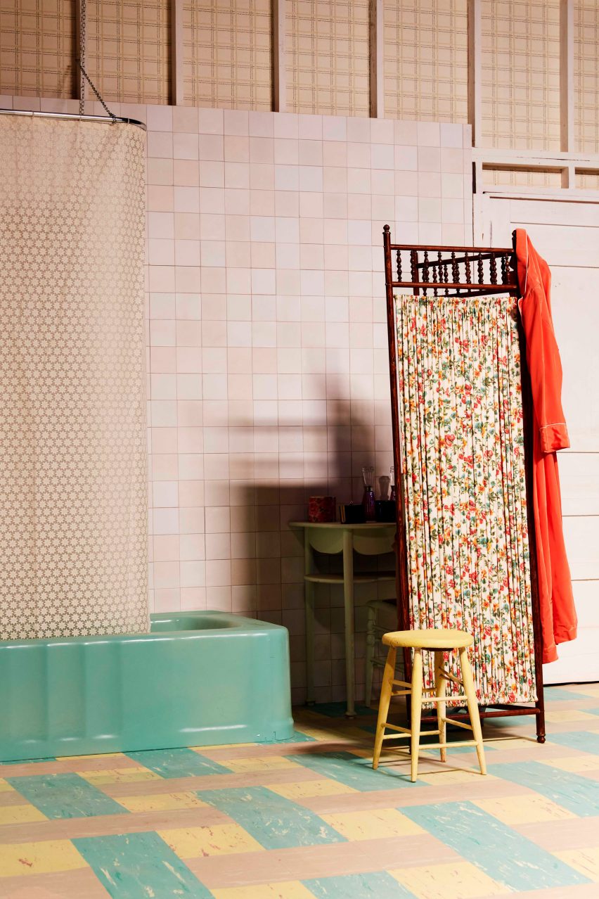 A bathroom film set with a blue bath tub and floral shower screen
