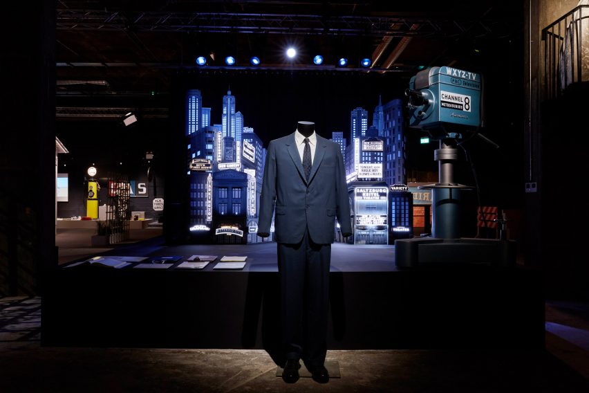 A blue suit displayed in front of a miniature city film set