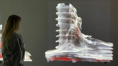 Person viewing sectional representation of multi-storey building on wall