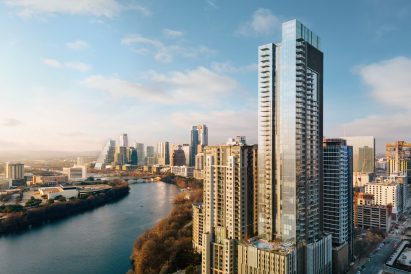 Exterior view of 44 East Avenue with the Colorado River and Austin skyline behind
