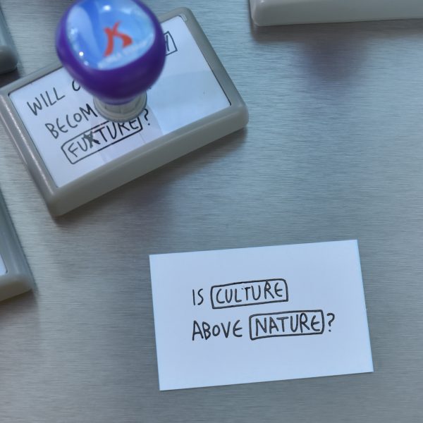 A photograph of a piece of paper that says "Is Culture Above Nature?"